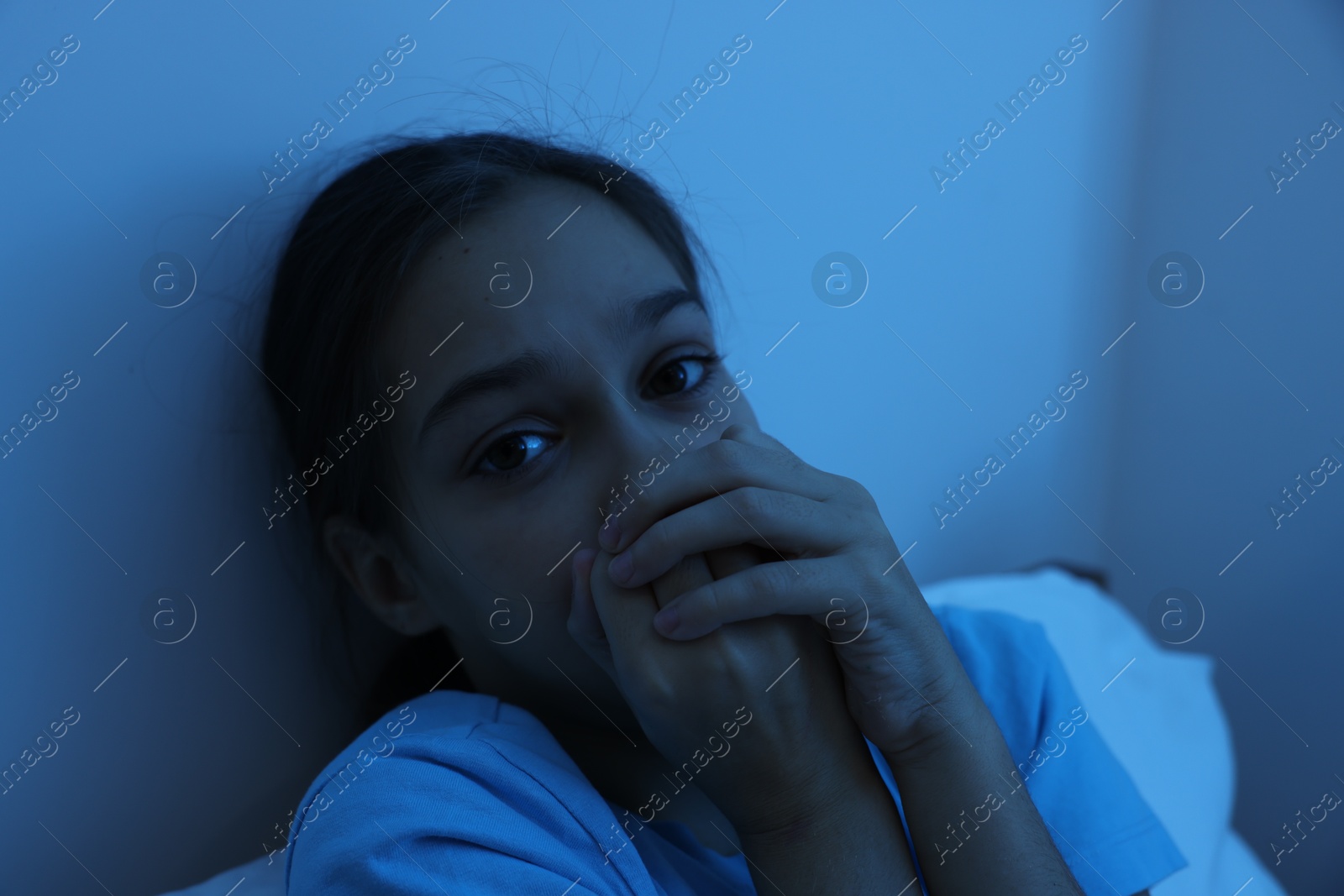 Photo of Fearful girl in her bed at night