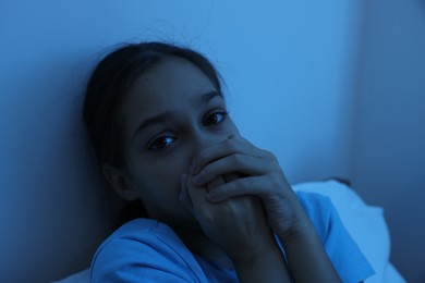 Photo of Fearful girl in her bed at night