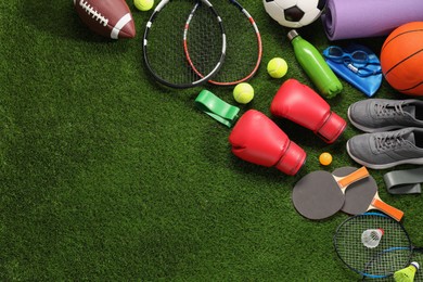 Photo of Different sport equipment on artificial grass, flat lay. Space for text