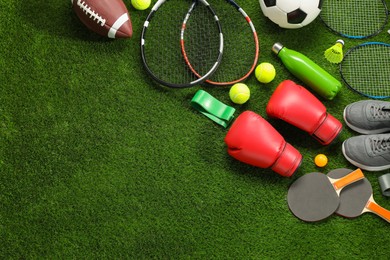 Photo of Different sport equipment on artificial grass, flat lay. Space for text