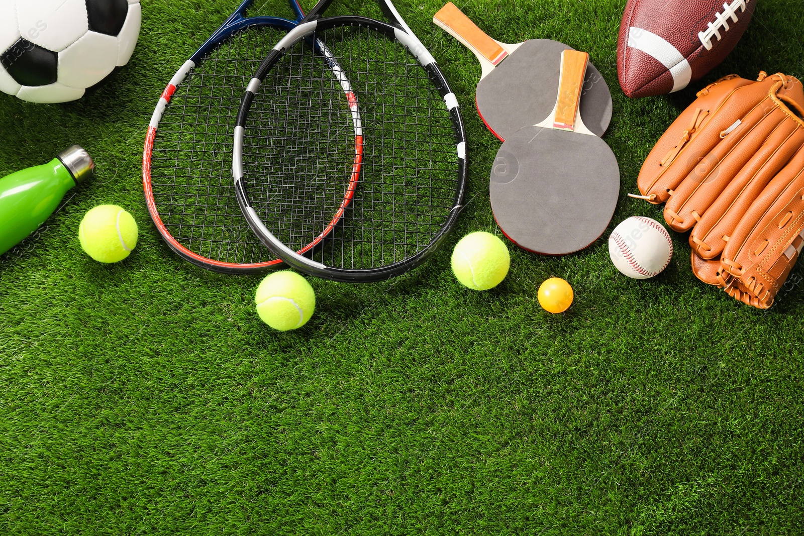 Photo of Different sport equipment on artificial grass, flat lay. Space for text