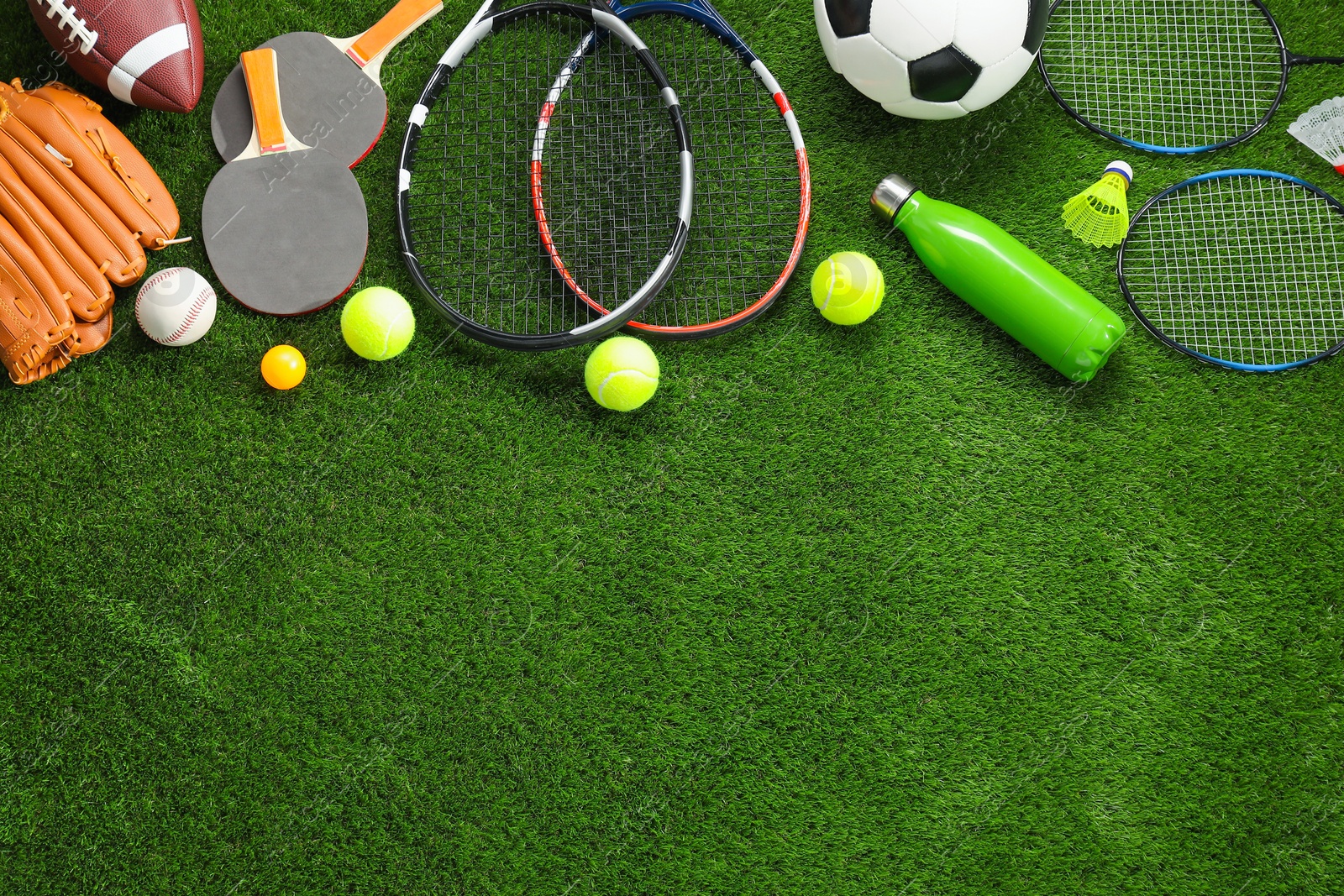 Photo of Different sport equipment on artificial grass, flat lay. Space for text