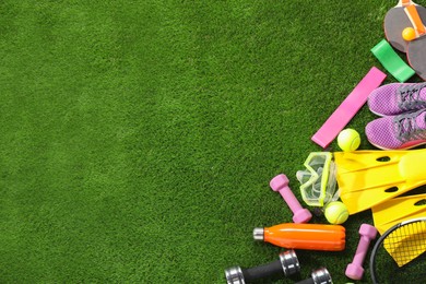 Photo of Different sport equipment on artificial grass, flat lay. Space for text