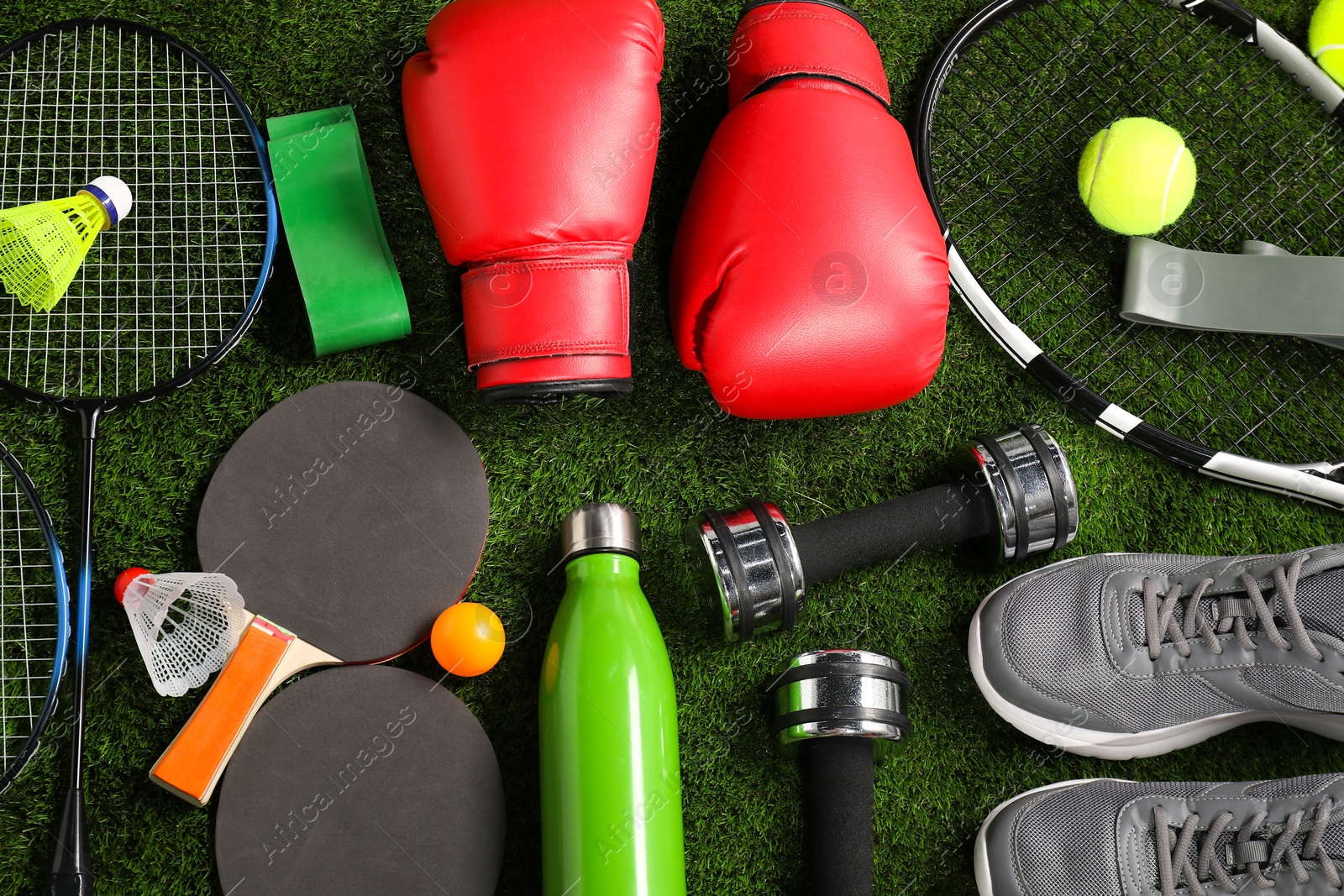 Photo of Different sport equipment on artificial grass, flat lay