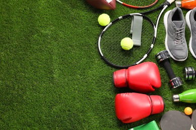 Photo of Different sport equipment on artificial grass, flat lay. Space for text