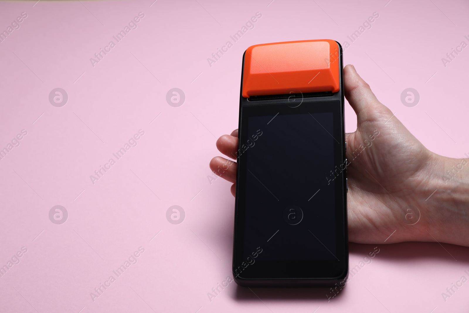 Photo of Woman with payment terminal on pink background, closeup. Space for text