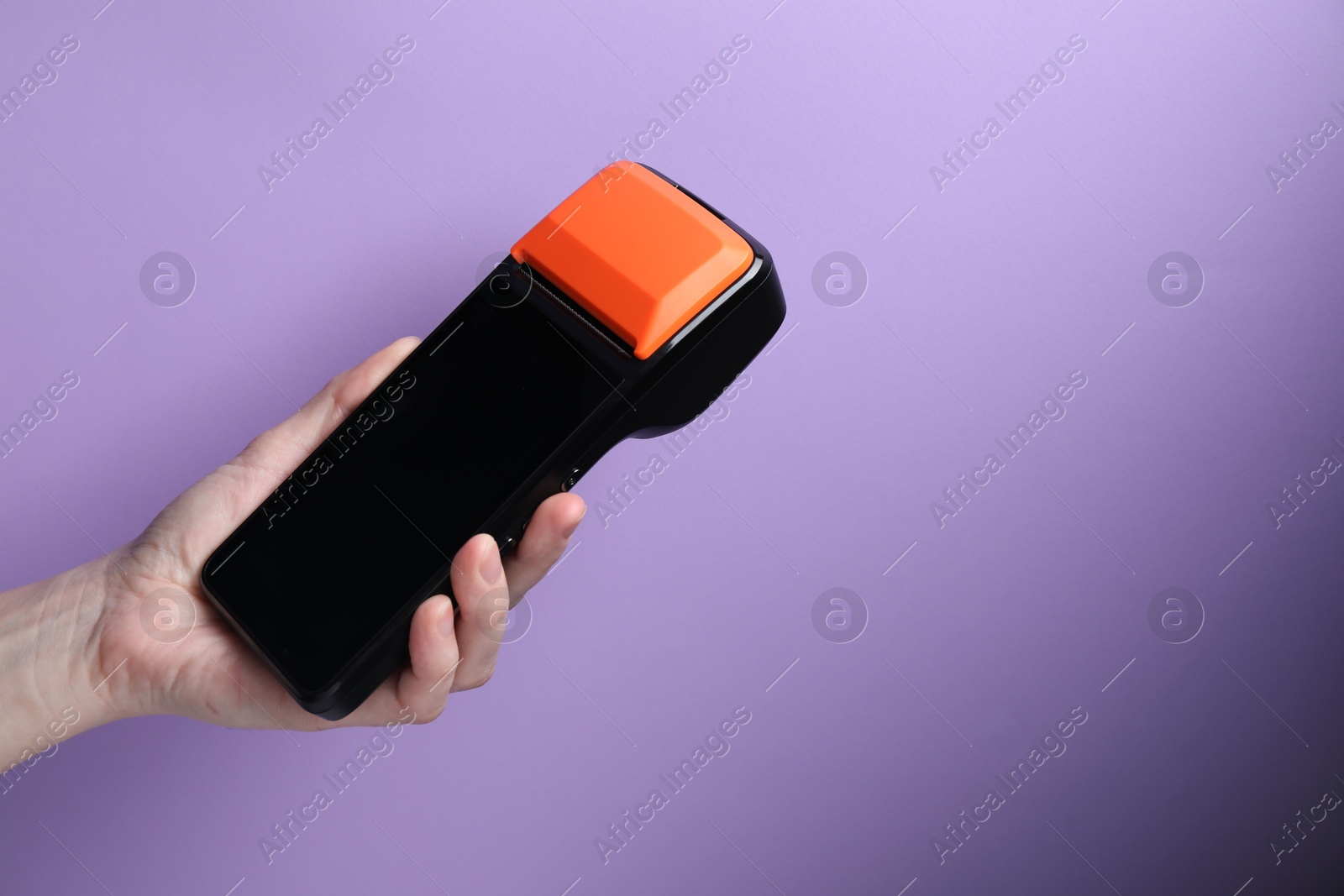 Photo of Woman with payment terminal on violet background, closeup. Space for text