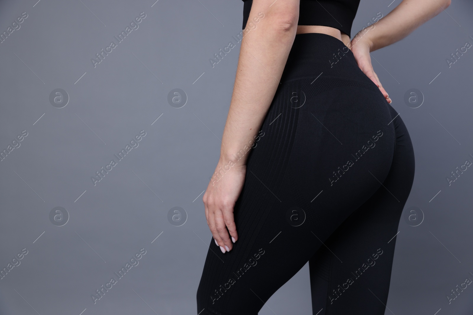 Photo of Woman in sportswear on grey background, closeup. Space for text