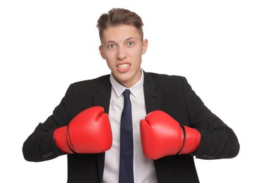 Photo of Competition. Angry businessman in suit wearing boxing gloves on white background