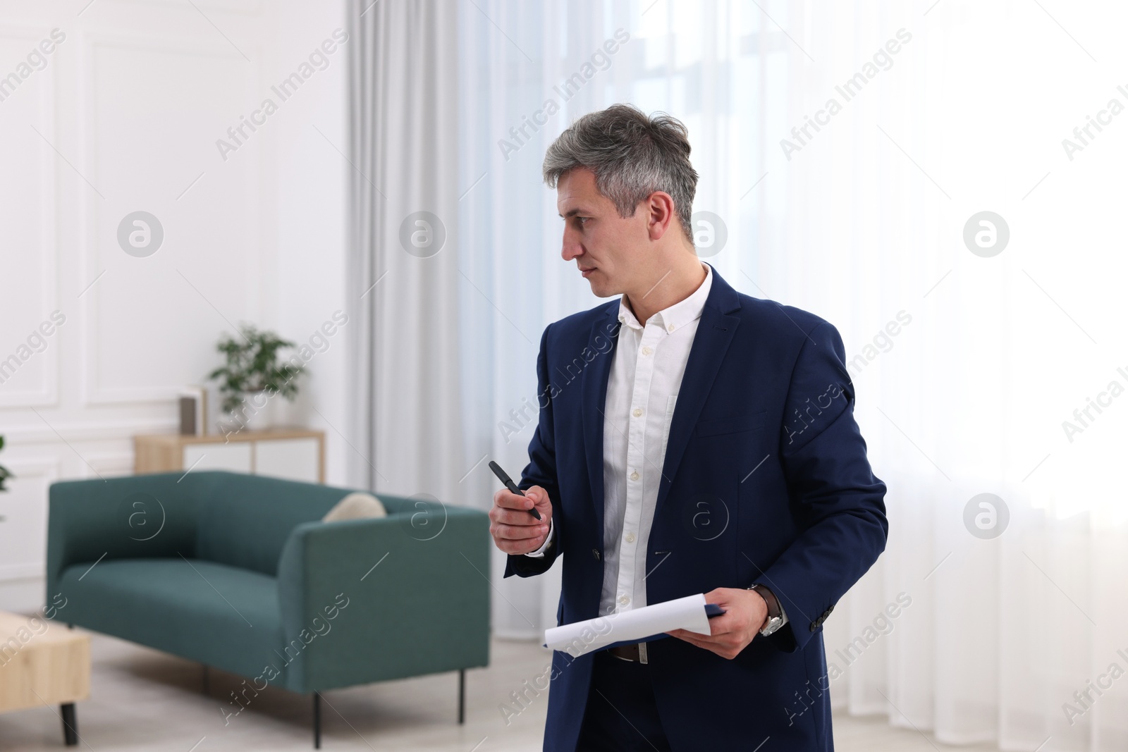 Photo of Real estate appraisal. Inspector with clipboard conducting property valuation at home