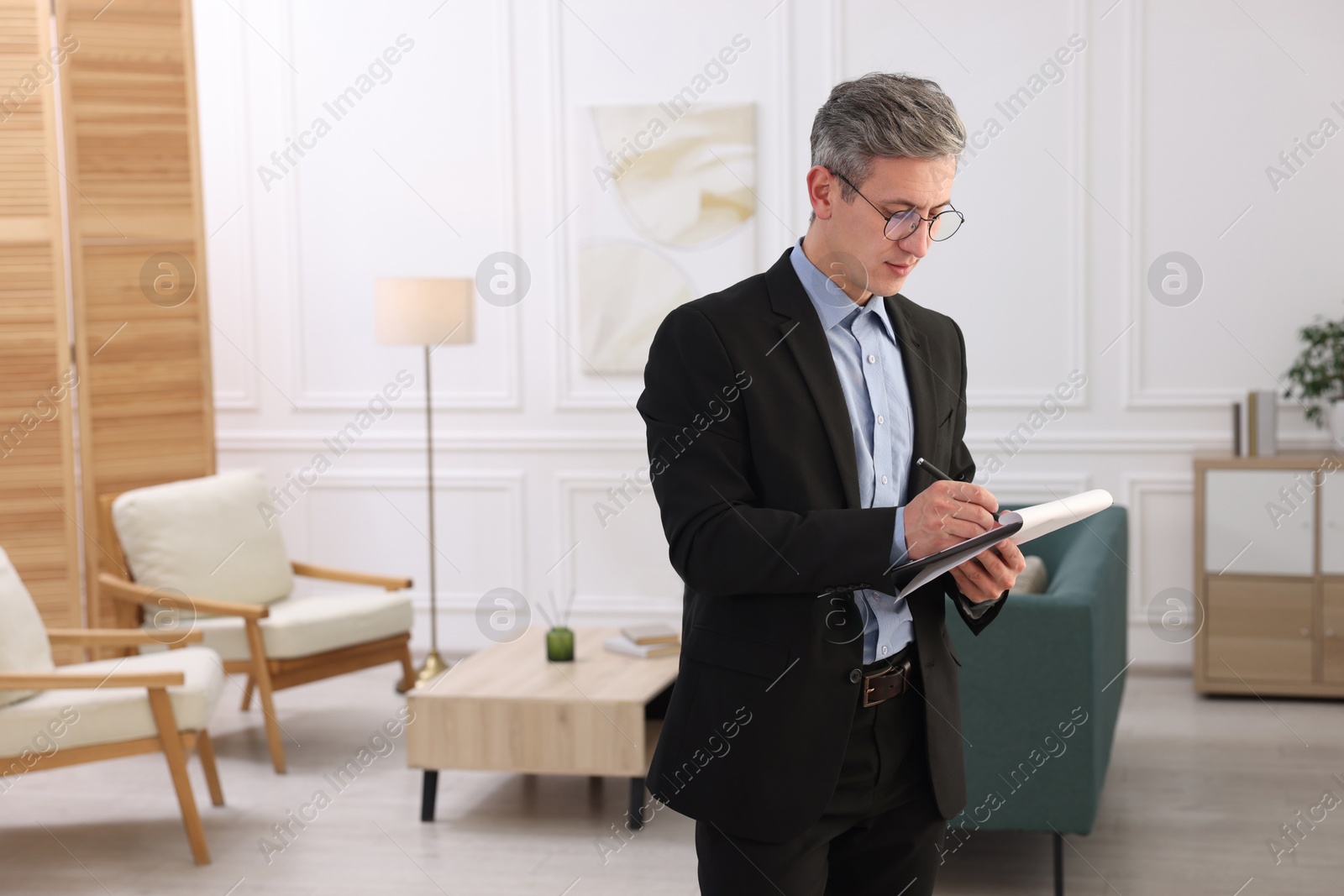 Photo of Real estate appraisal. Inspector with clipboard conducting property valuation at home. Space for text