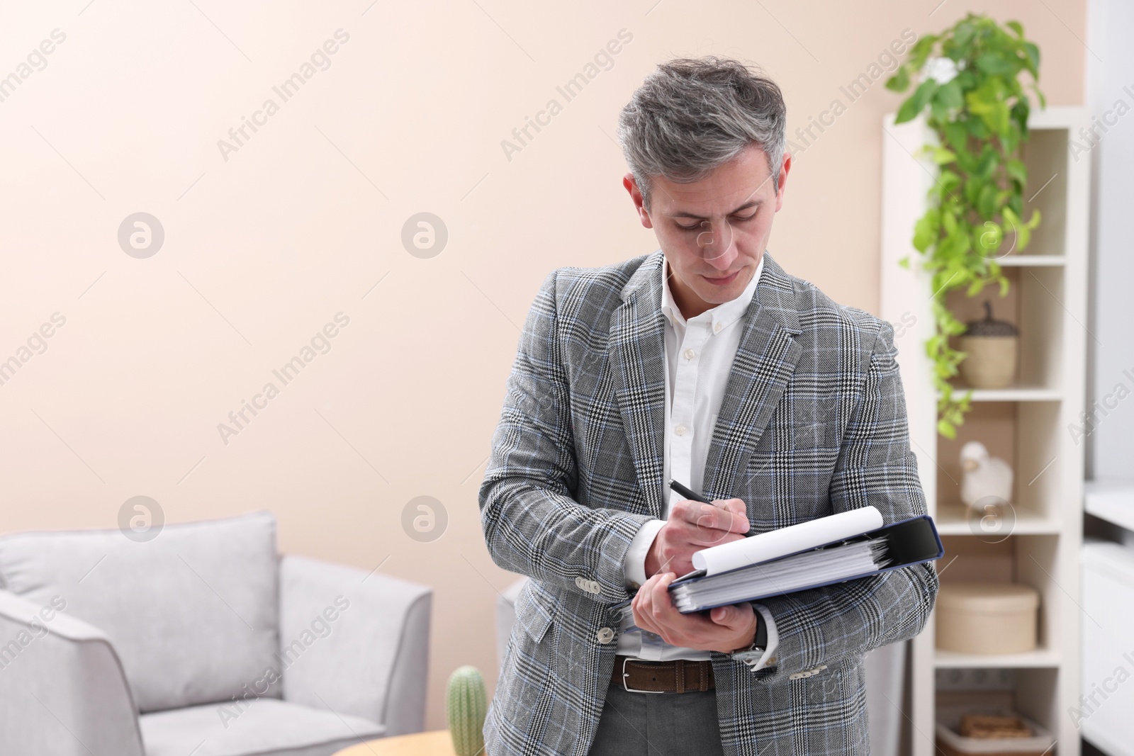 Photo of Real estate appraisal. Inspector with clipboard conducting property valuation at home. Space for text