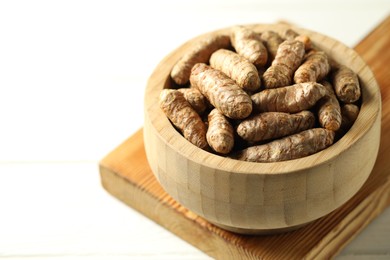 Photo of Raw tumeric rhizomes on white table, closeup. Space for text