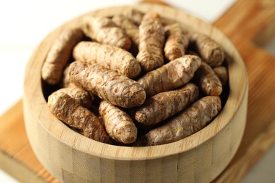 Photo of Raw tumeric rhizomes on white table, closeup