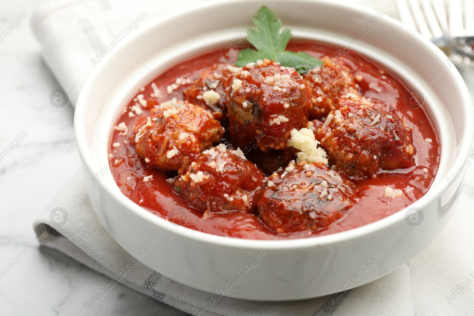 Photo of Delicious meatballs with tomato sauce, parmesan cheese and parsley on table, closeup