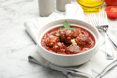 Photo of Delicious meatballs with tomato sauce, parmesan cheese and parsley served on white marble table, closeup