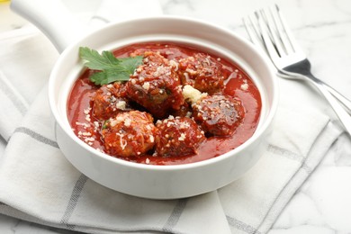 Photo of Delicious meatballs with tomato sauce, parmesan cheese and parsley served on white table, closeup