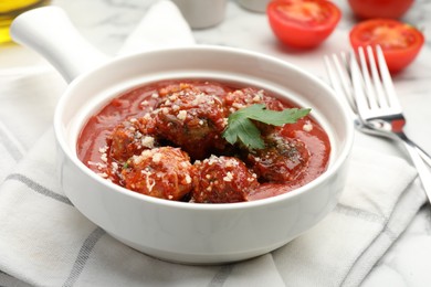 Photo of Delicious meatballs with tomato sauce, parmesan cheese and parsley served on white table, closeup