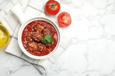 Photo of Delicious meatballs with tomato sauce, parmesan cheese and parsley served on white marble table, top view. Space for text