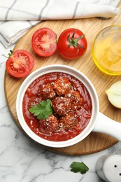 Photo of Delicious meatballs with tomato sauce, parmesan cheese and parsley served on white marble table, flat lay