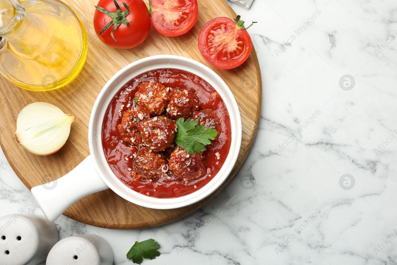 Photo of Delicious meatballs with tomato sauce, parmesan cheese and parsley served on white marble table, flat lay. Space for text