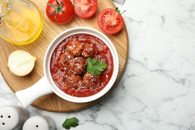 Photo of Delicious meatballs with tomato sauce, parmesan cheese and parsley served on white marble table, flat lay. Space for text