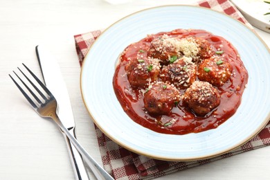 Photo of Delicious meatballs with tomato sauce, parmesan and herbs in served on white wooden table, closeup