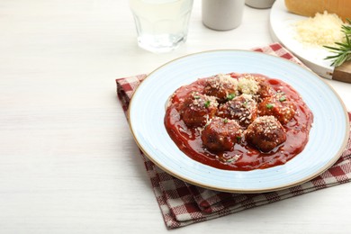 Photo of Delicious meatballs with tomato sauce, parmesan and herbs in on white wooden table. Space for text