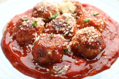 Photo of Delicious meatballs with tomato sauce, parmesan and herbs in bowl, closeup