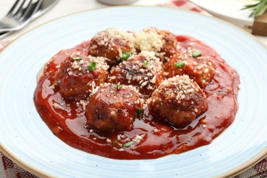 Photo of Delicious meatballs with tomato sauce, parmesan and herbs in on table, closeup