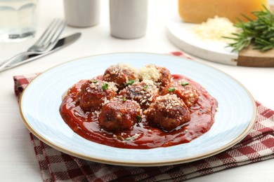 Photo of Delicious meatballs with tomato sauce, parmesan and herbs in served on white wooden table, closeup