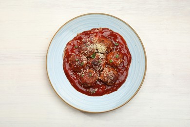 Photo of Delicious meatballs with tomato sauce, parmesan and herbs in on white wooden table, top view