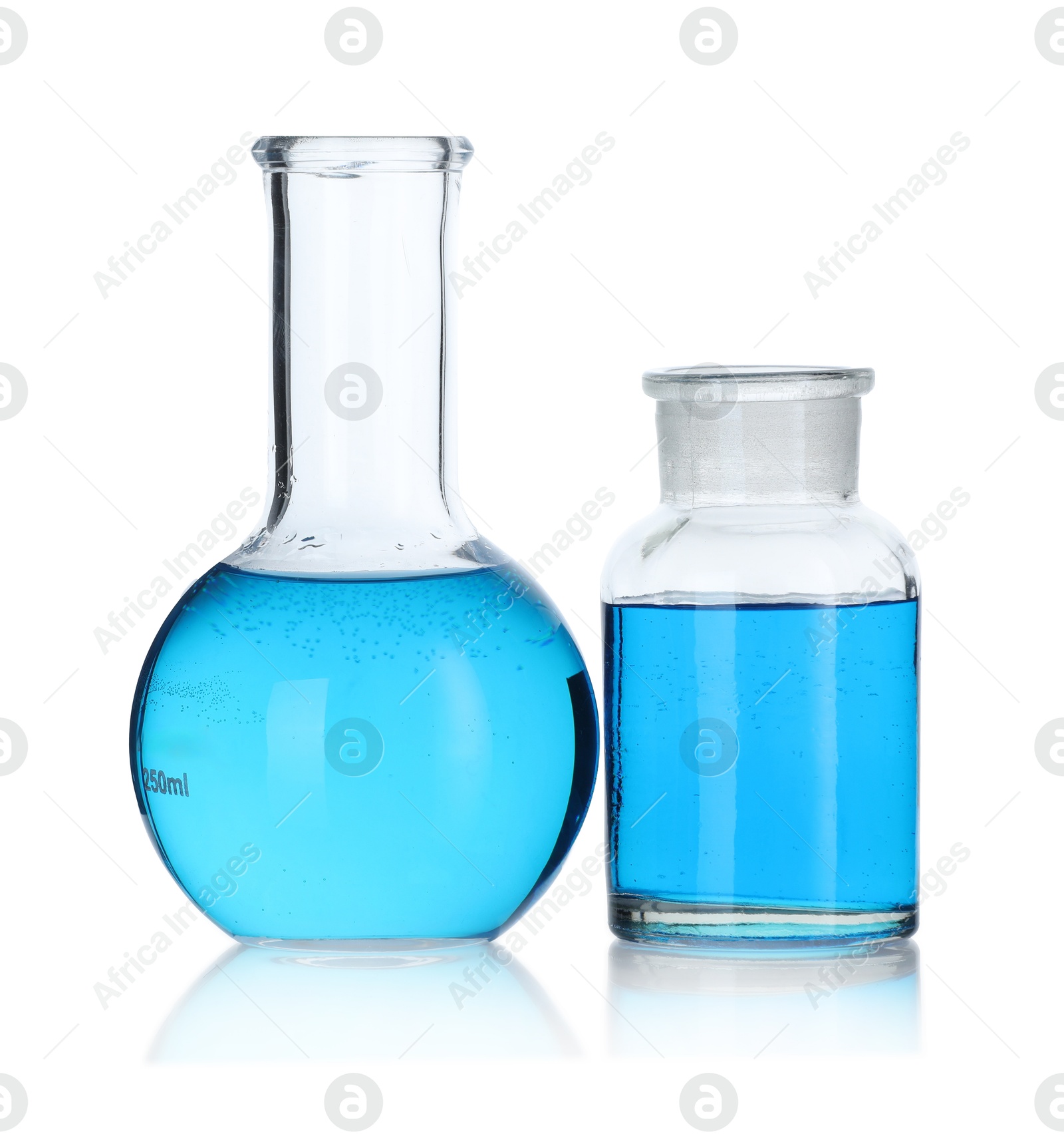 Photo of Glass flasks with light blue liquid on mirror surface against white background