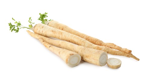 Photo of Whole and cut fresh parsley roots isolated on white