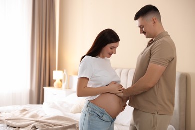 Photo of Pregnant woman and her husband at home, space for text