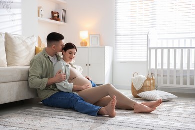 Photo of Pregnant woman and her husband on floor at home