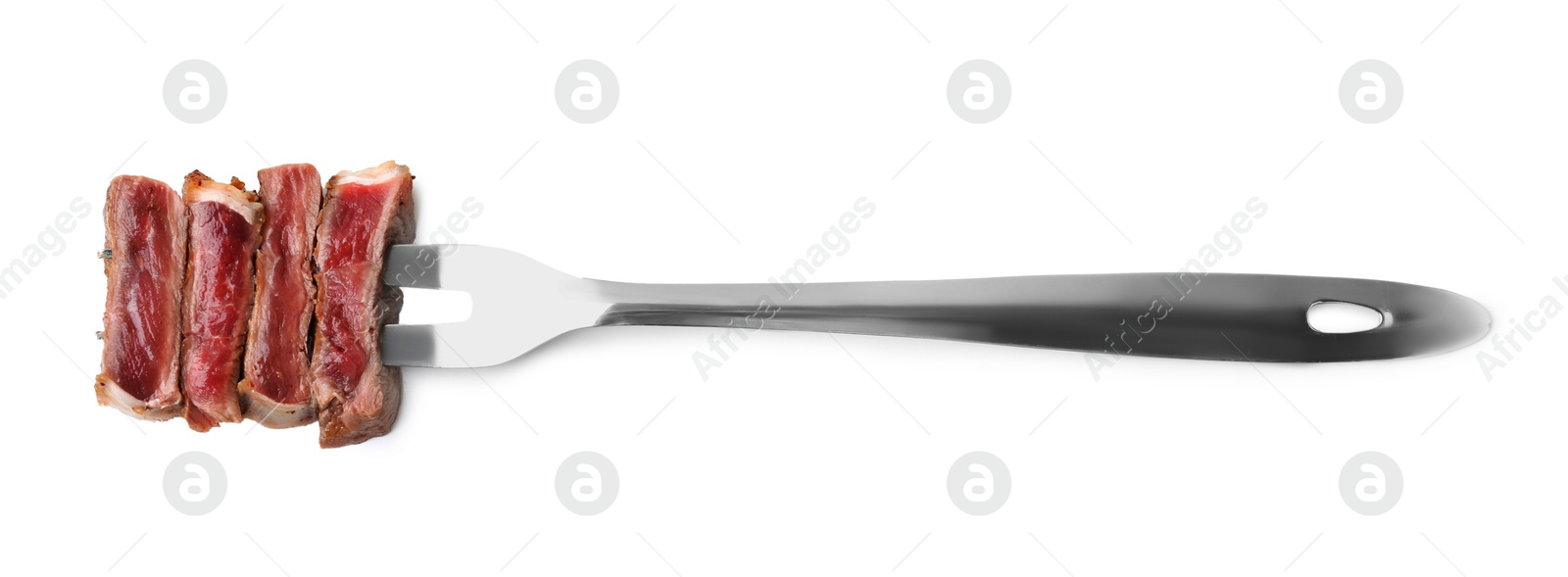 Photo of Carving fork with pieces of delicious beef meat isolated on white, top view