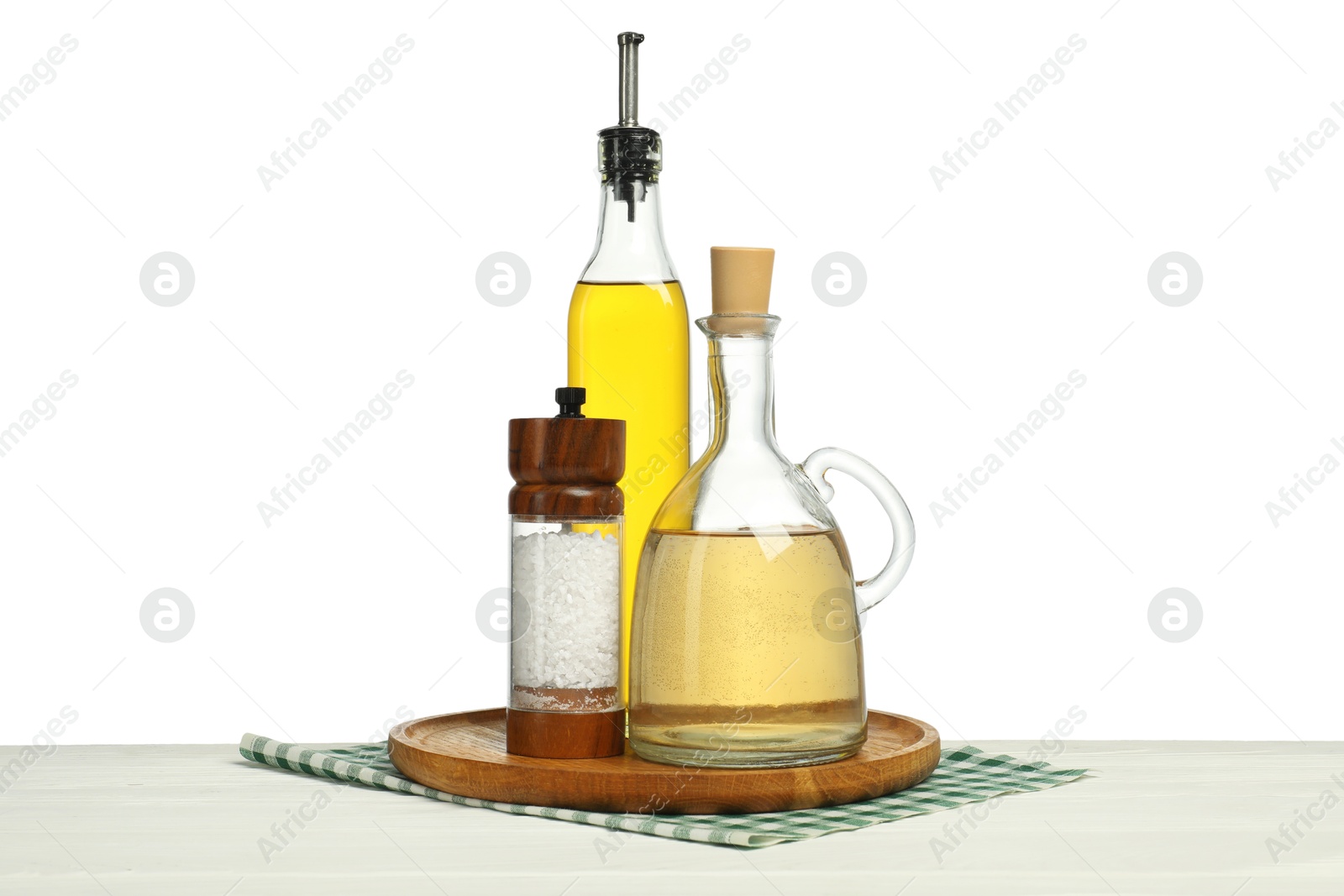 Photo of Salad dressings and salt on wooden table against white background