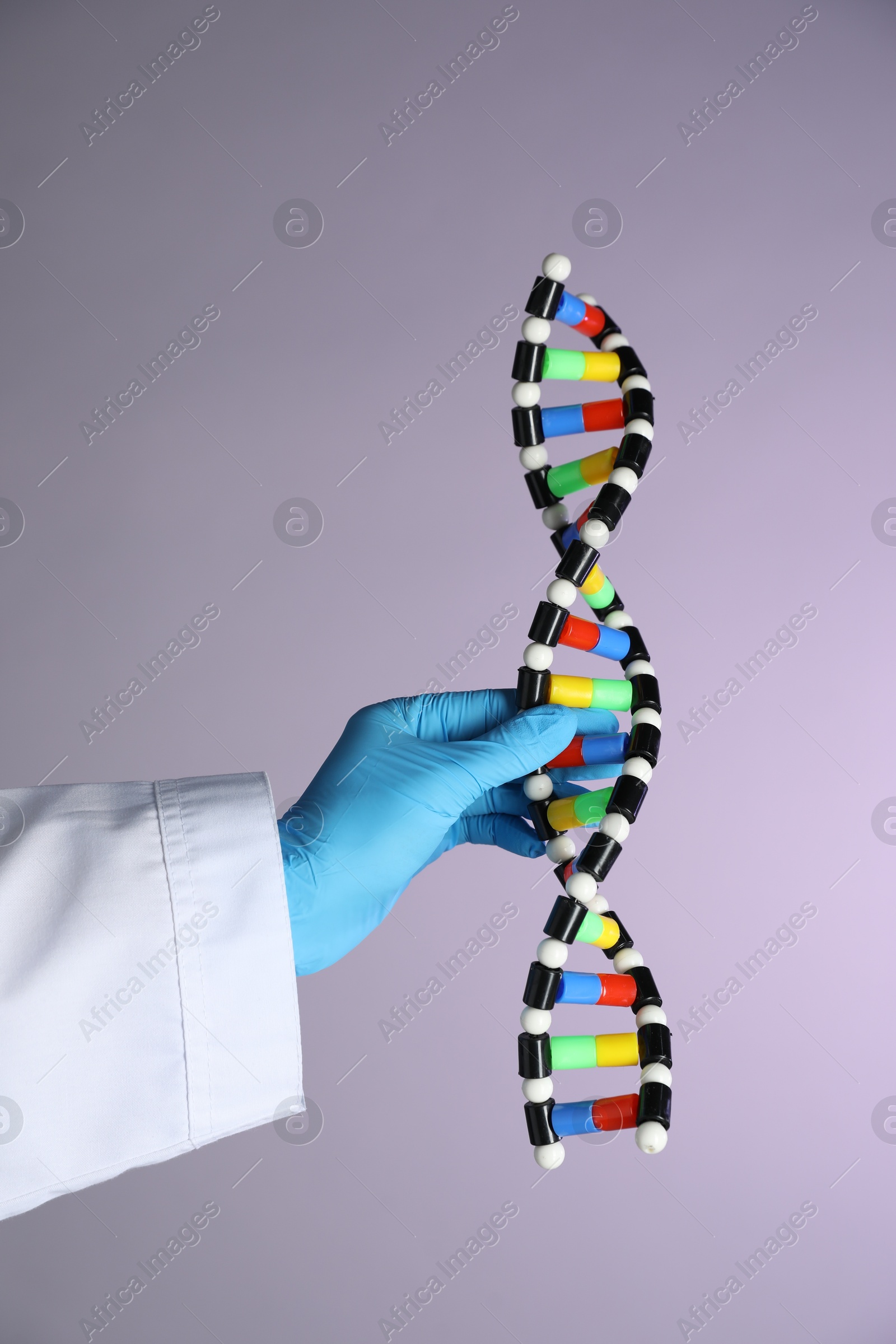 Photo of Scientist with DNA structure model on color background, closeup