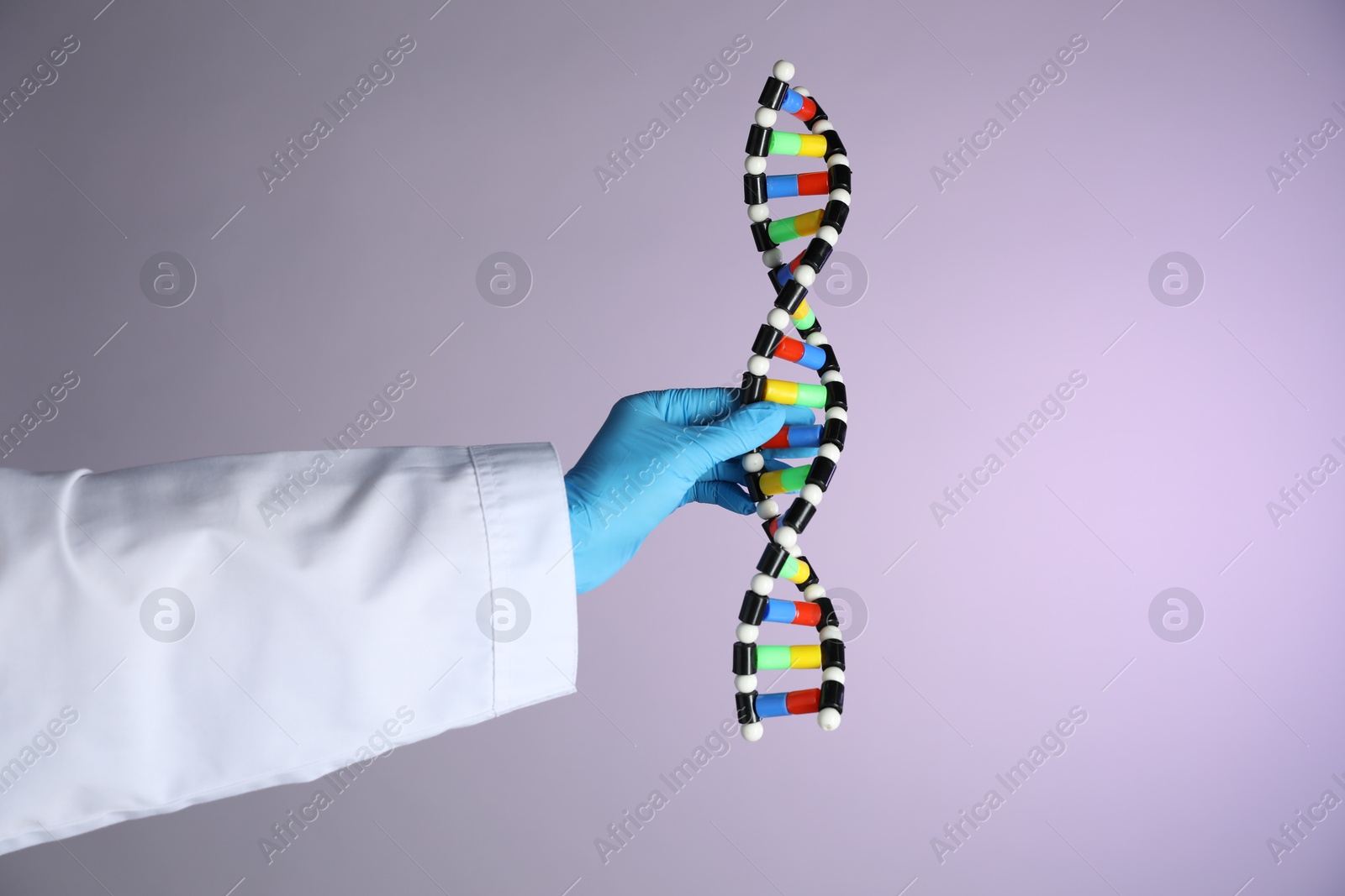 Photo of Scientist with DNA structure model on color background, closeup