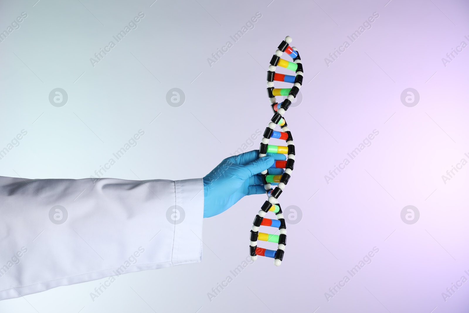 Photo of Scientist with DNA structure model on color background, closeup