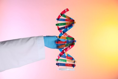 Photo of Scientist with DNA structure model on color background, closeup