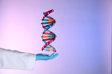 Photo of Scientist with DNA structure model on color background, closeup