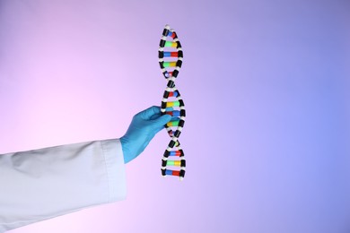 Photo of Scientist with DNA structure model on color background, closeup