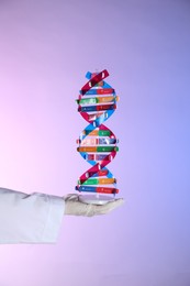 Photo of Scientist with DNA structure model on color background, closeup