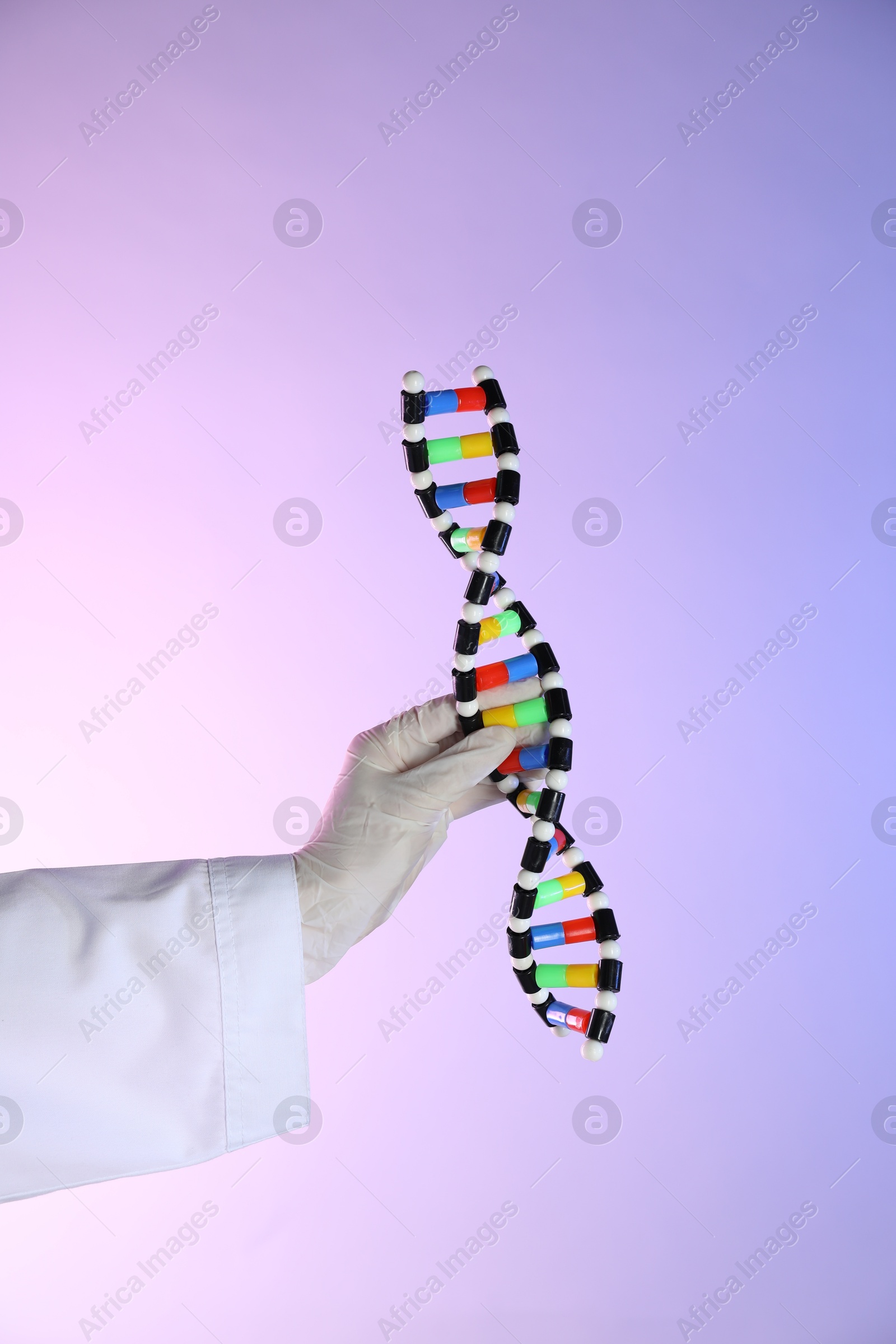 Photo of Scientist with DNA structure model on color background, closeup