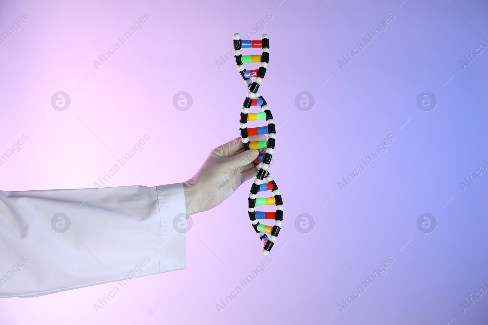 Photo of Scientist with DNA structure model on color background, closeup