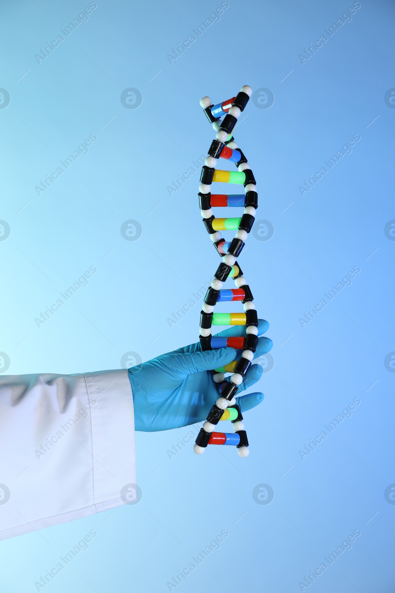 Photo of Scientist with DNA structure model on color background, closeup