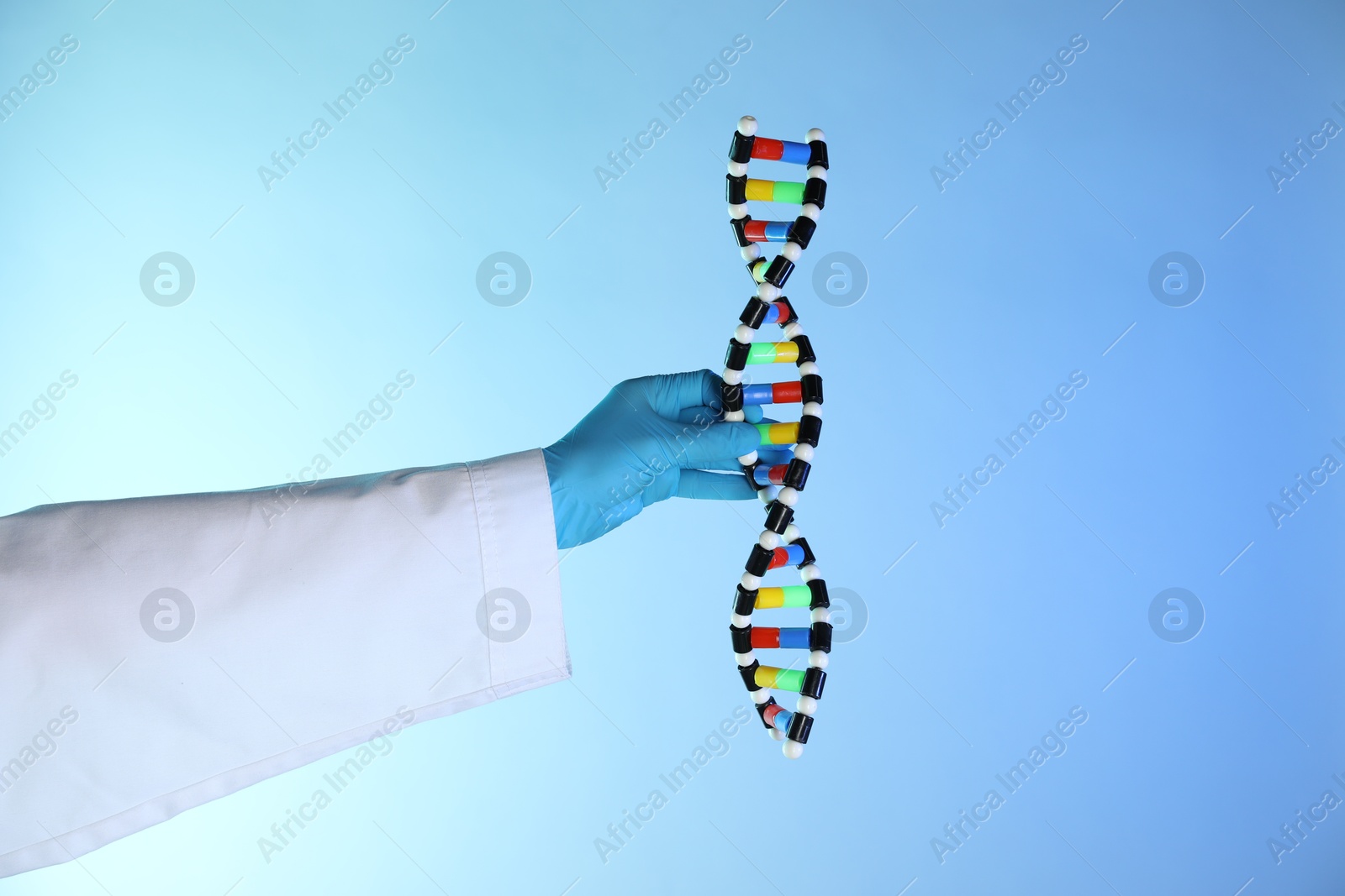 Photo of Scientist with DNA structure model on color background, closeup