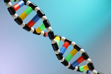 Photo of DNA structure model on color background, closeup